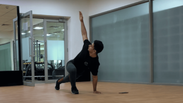 A man in a yoga pose at the gym, demonstrating strength and focus in a fitness environment. - Fitsse