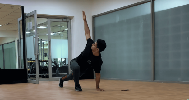 A man in a yoga pose at the gym, demonstrating strength and focus in a fitness environment. - Fitsse